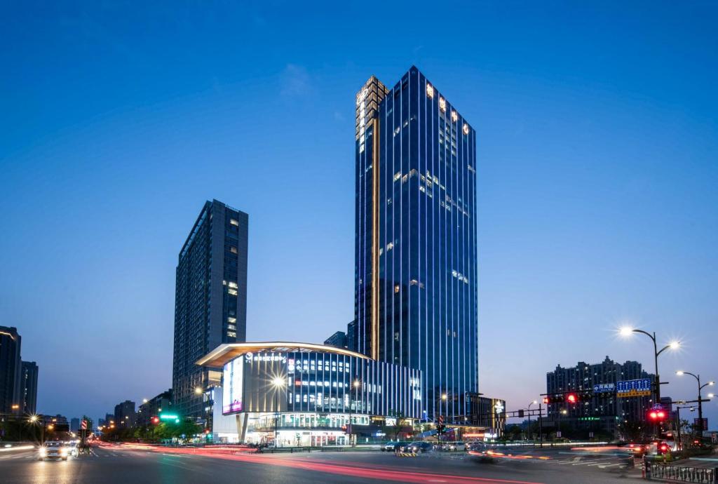 un perfil urbano con edificios altos por la noche en Crowne Plaza Hangzhou Linping, an IHG Hotel, en Hangzhou