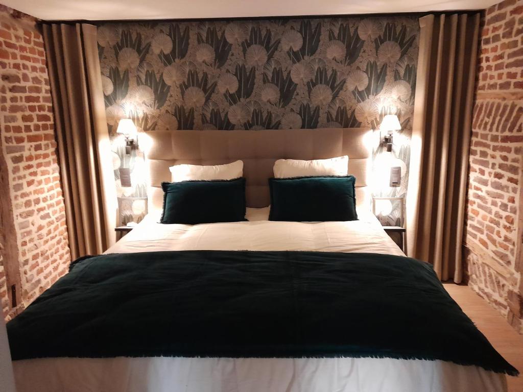 Un pat sau paturi într-o cameră la Le Coq d'or