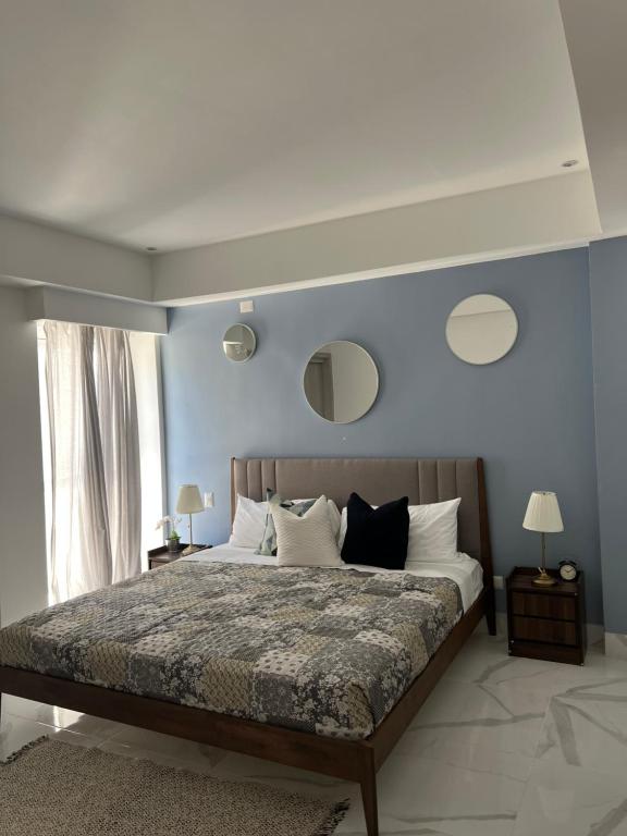 a bedroom with a large bed with blue walls at Cozy condo beach acsess cap cana in Punta Cana