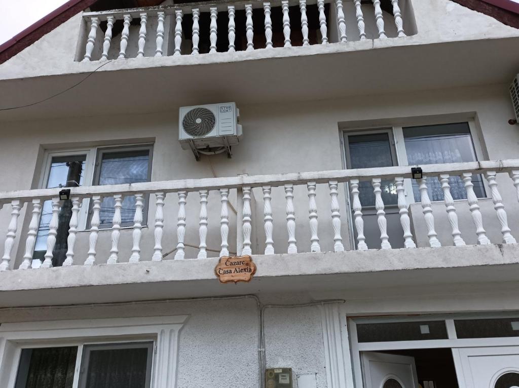 a white house with a balcony and a fan at Casa Alexia in Coronini