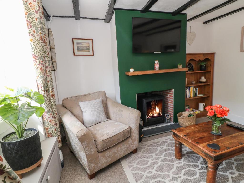a living room with a chair and a fireplace at CurLi Cottage in Bideford