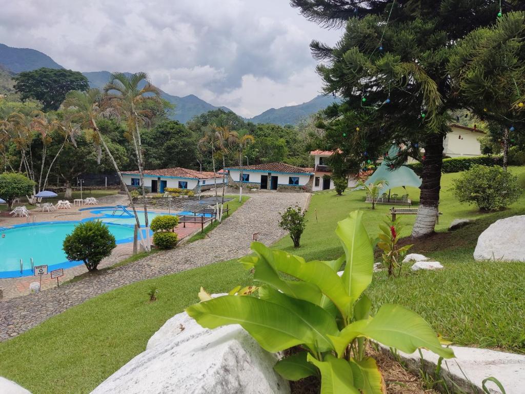 un complejo con piscina y montañas de fondo en Hosteria Puerta del Nus en Cisneros