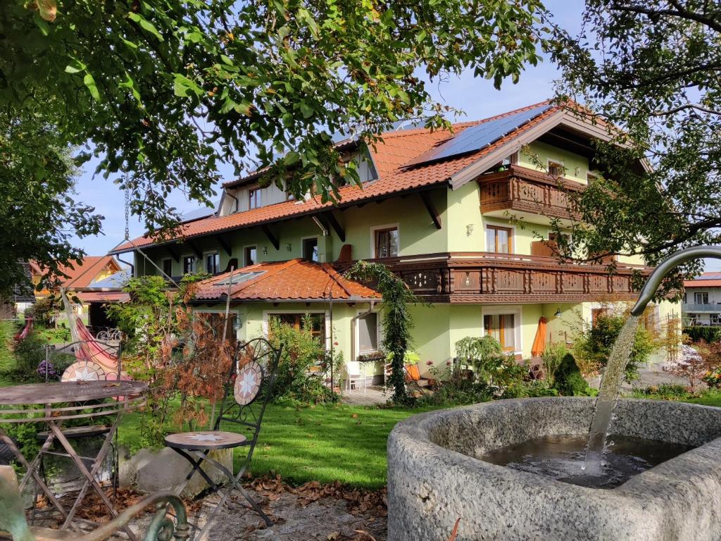 a house with a fountain in front of it at Pension Holzapfel in Sankt Georgen im Attergau