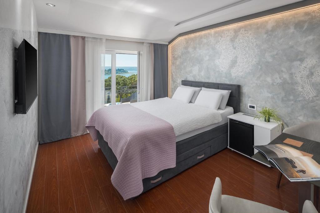a bedroom with a large bed and a window at Hotel Tomi in Portorož