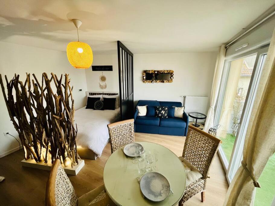 un salon avec une table, des chaises et un canapé dans l'établissement L’Atelier des rêves à 200 m de la plage, à Fort-Mahon-Plage