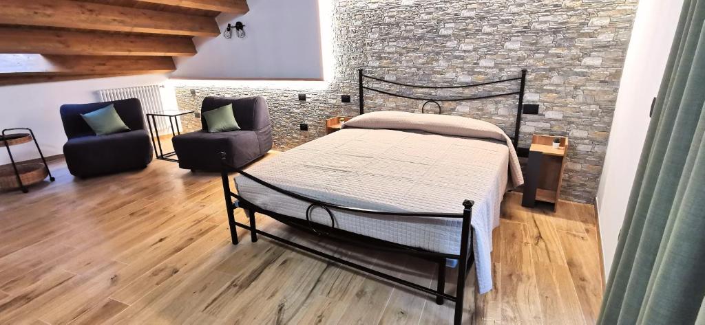 1 dormitorio con cama y pared de ladrillo en Dietro le mura en Casoli