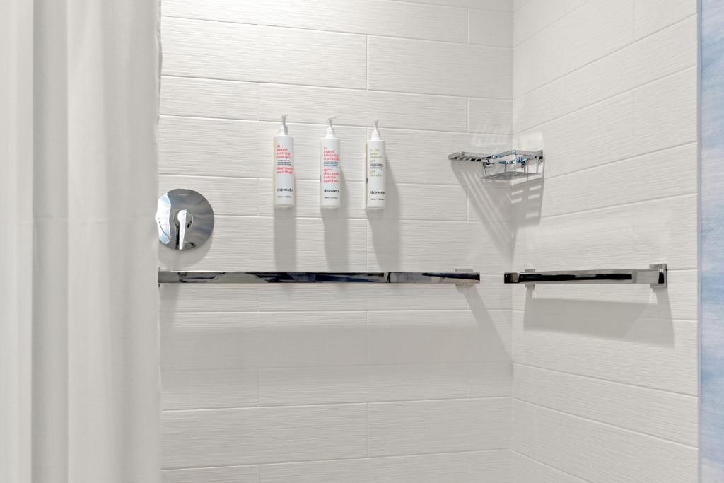 uma casa de banho com 3 escovas de dentes brancas num chuveiro em Marriott San Antonio Airport em San Antonio