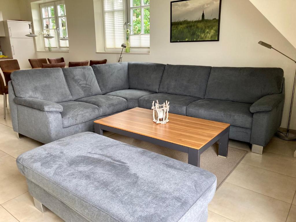 a living room with a gray couch and a wooden table at Ferienhaus Grodenblick Sanddorn Whg 3 in Wangerooge