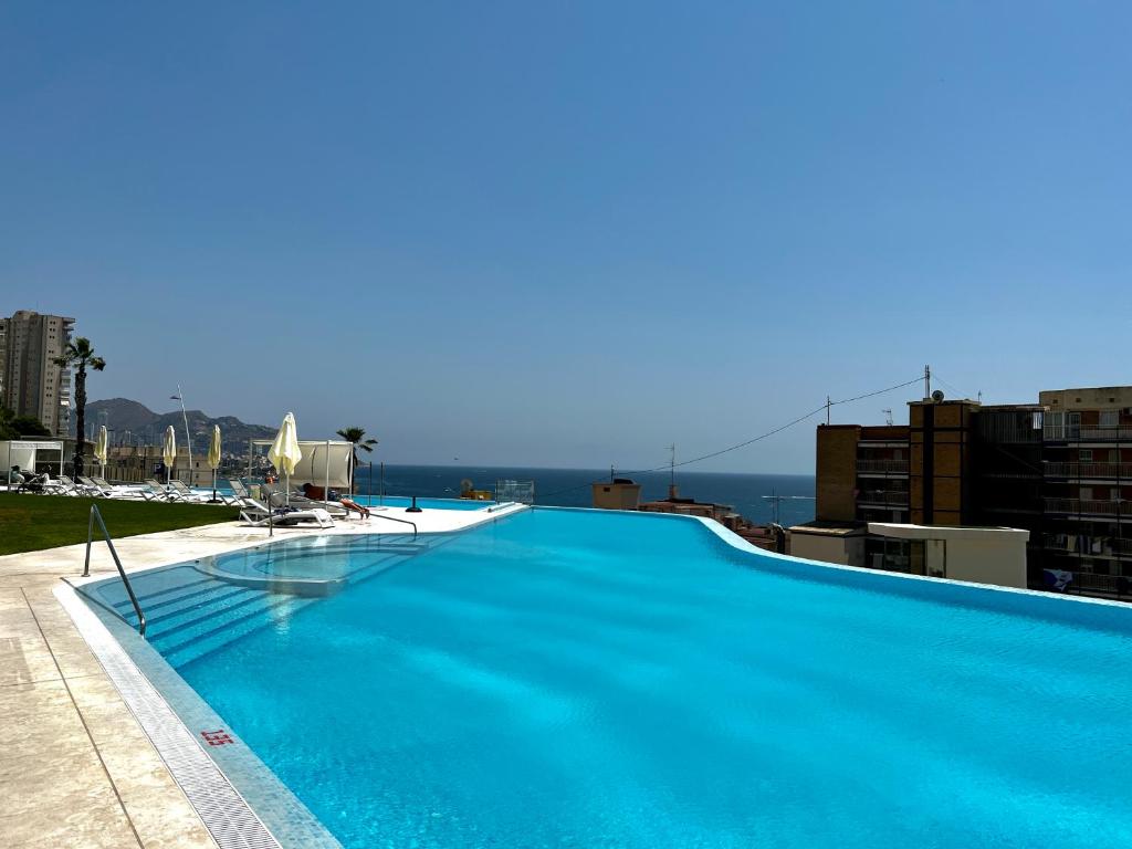 a large blue swimming pool on top of a building at Luxury apartment with stunning sea views in Sunset Cliff Benidorm in Benidorm