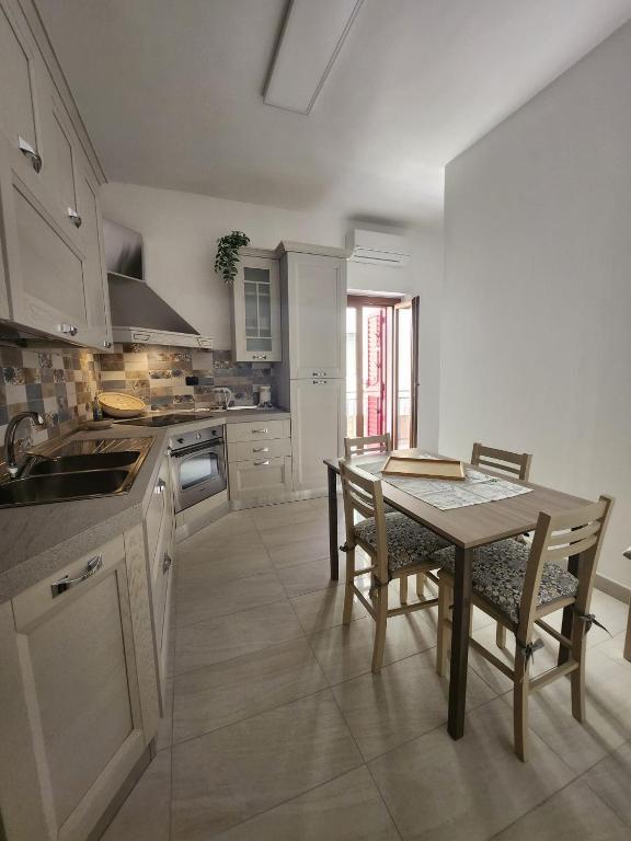 eine Küche mit einem Tisch und Stühlen in der Unterkunft Il Pizzuto - Appartamento da Nonno Dino in Bernalda