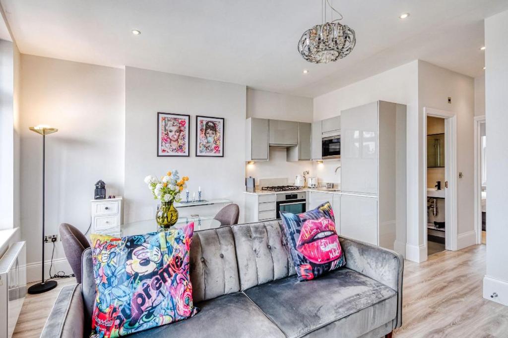 a living room with a couch and a kitchen at Elegant 1 bed apartment- Hampstead Village in London
