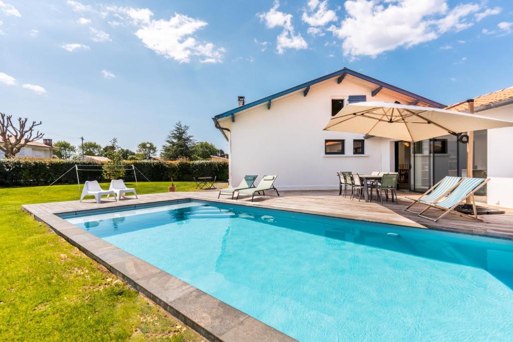 uma villa com uma piscina e uma casa em Villa de 4 chambres avec piscine privee jardin clos et wifi a Seignosse a 5 km de la plage em Seignosse