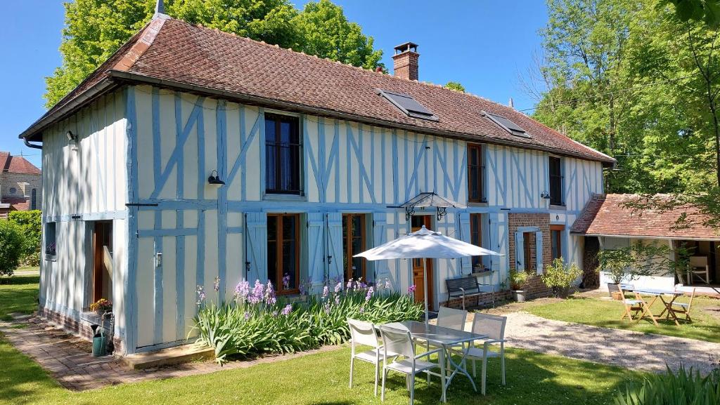 una casa blu e bianca con tavolo e ombrellone di Domaine du Carouge a Lirey