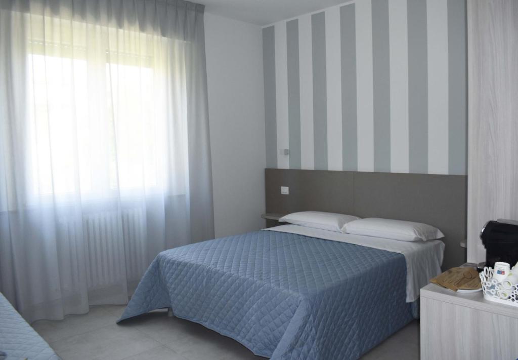 um quarto com uma cama azul e uma janela em Marcelli Mare Camere Nel Conero em Numana