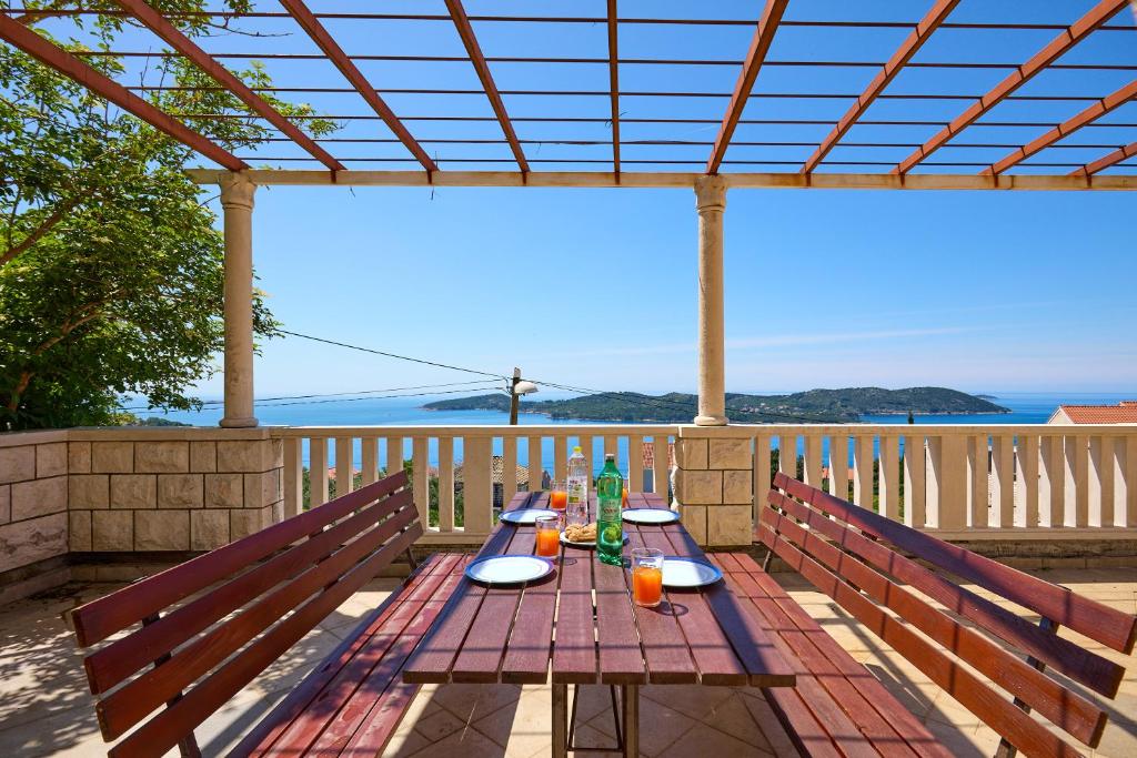 a picnic table on a deck with a view of the ocean at Helton SeaView Apartments in Orasac