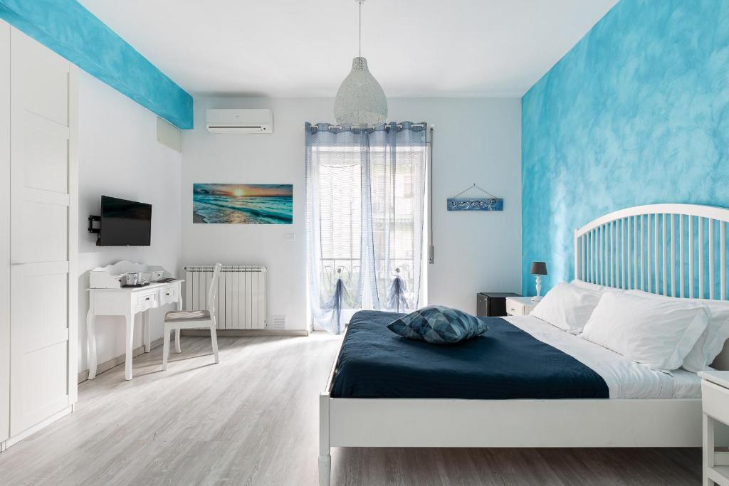 een blauwe slaapkamer met een bed en een bureau bij B&B Sapore di Mare in Gaeta