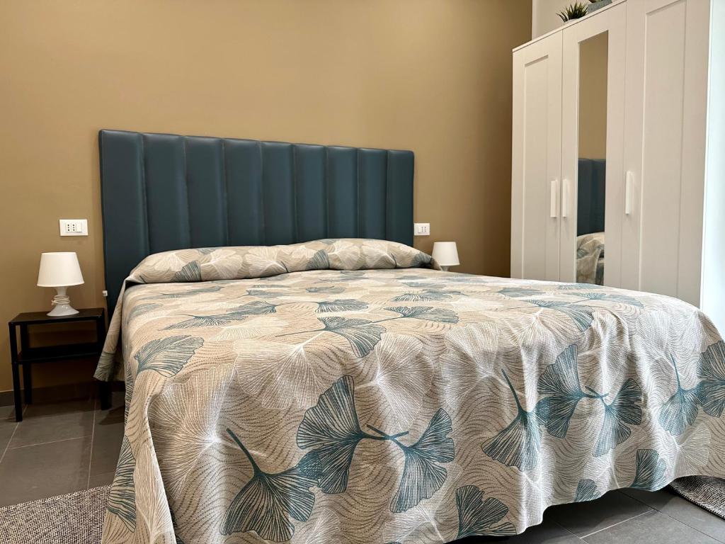a bedroom with a large bed with a blue headboard at La Corte 25 in Marsala