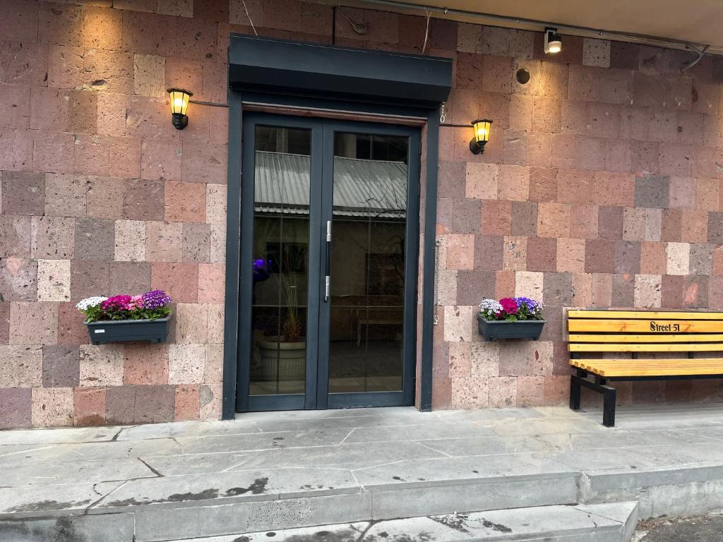 a bench sitting in front of a building with flowers at Street51 in Yerevan