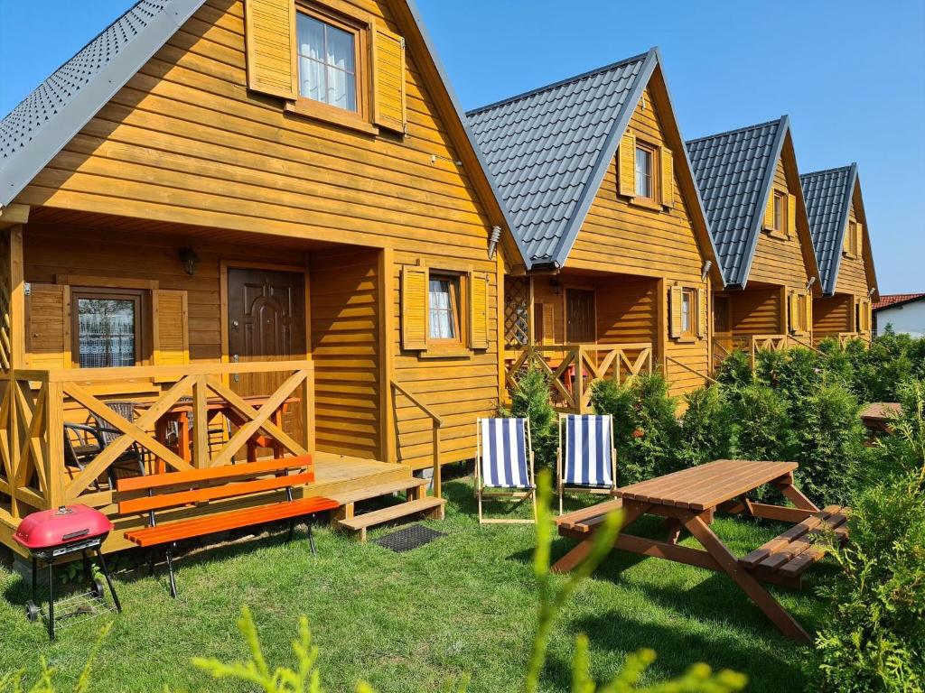 a wooden cabin with a picnic table in front of it at Holiday Home in Jaros awiec near Beach & Cliff in Jarosławiec