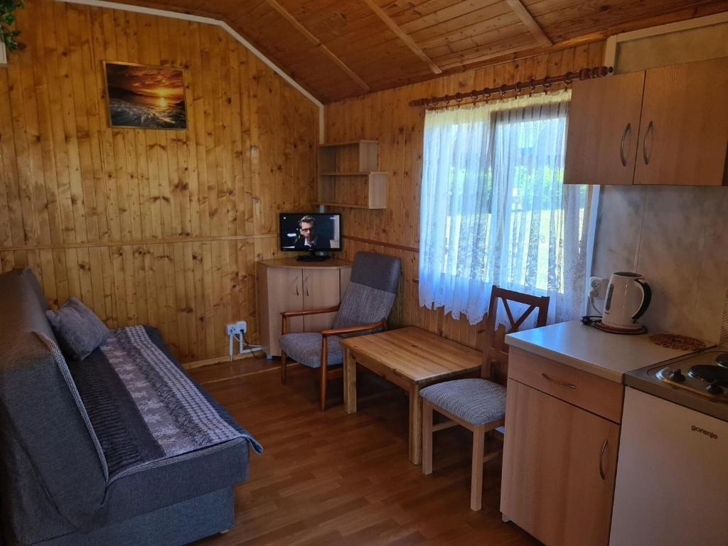 a kitchen and living room with a couch and a table at Cozy holiday homes near the beach in Jaros awiec in Jarosławiec