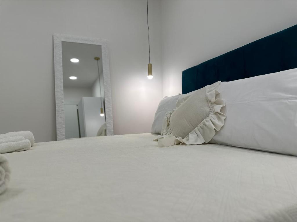 ein weißes Bett mit weißen Kissen darüber in der Unterkunft La vie est belle in Neapel