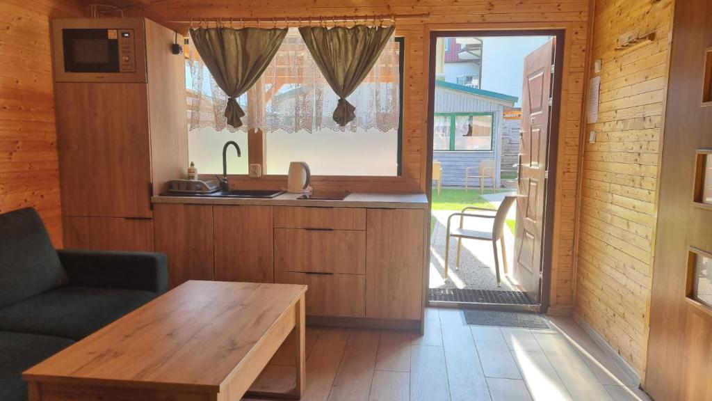 a living room with a table and a kitchen at Domki u Wiki in Niechorze