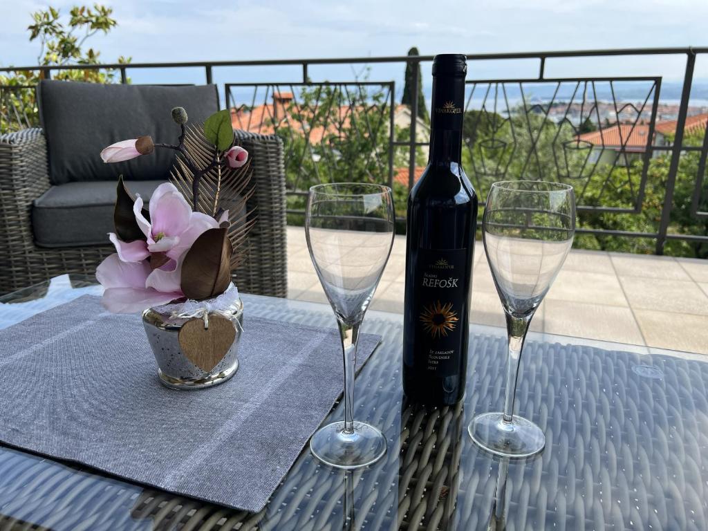 un tavolo con due bicchieri di vino e una bottiglia di vino di Magnolia Apartments a Izola