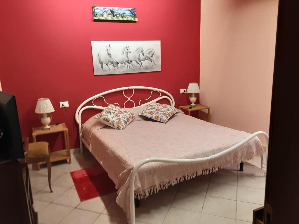 a bedroom with a bed with a red wall at La casetta di nonna Sesa in Viterbo