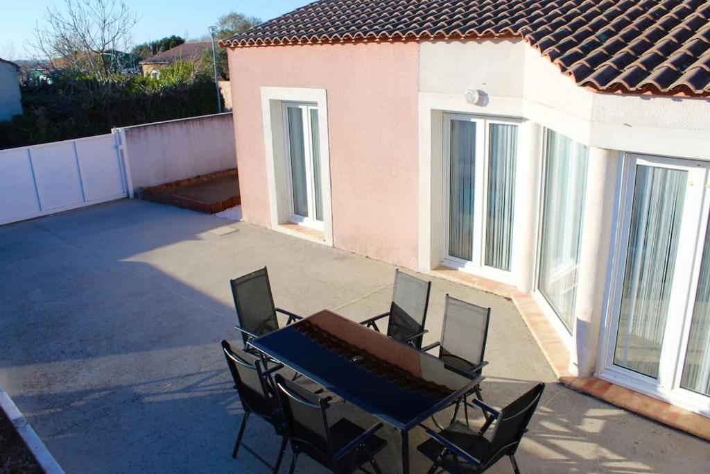 un patio avec une table et des chaises dessus dans l'établissement Maison sur les hauteurs de Carcassonne, à Carcassonne