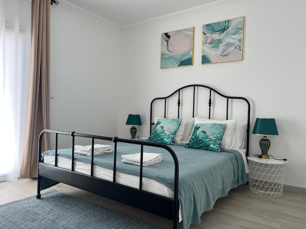 een slaapkamer met een zwart bed met blauwe kussens bij Hope House Parede in Parede