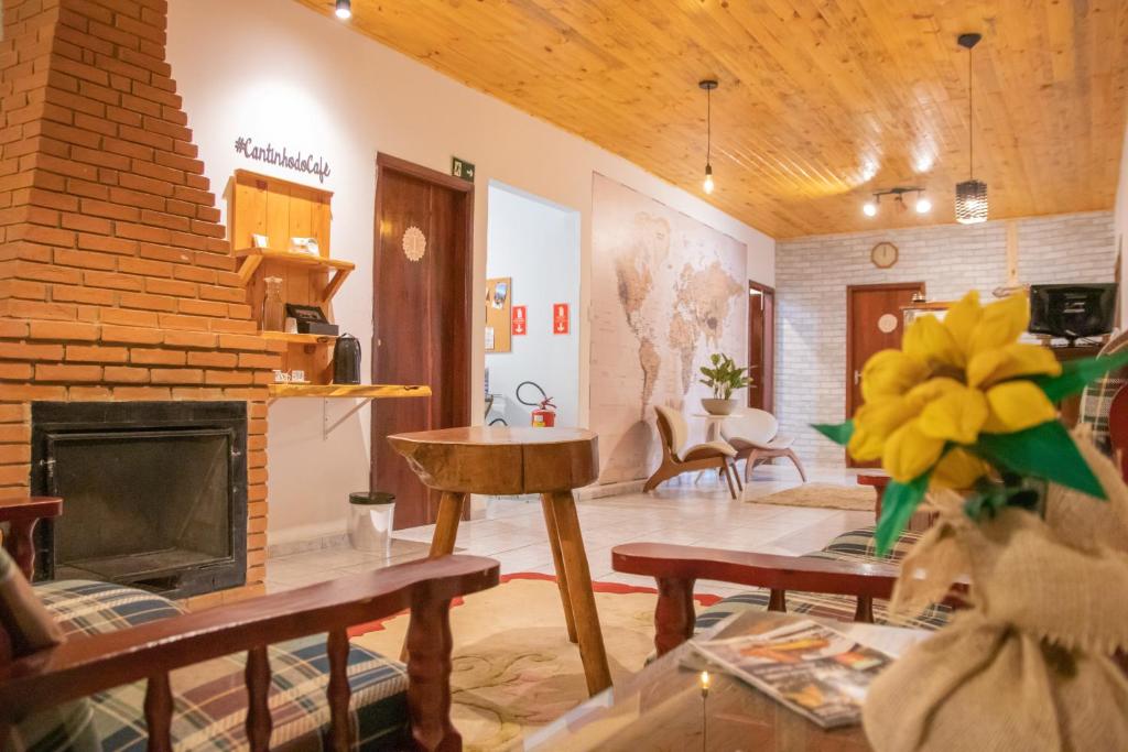 a living room with a fireplace and a brick wall at POUSADA GIRASSOL in Santo Antônio do Pinhal