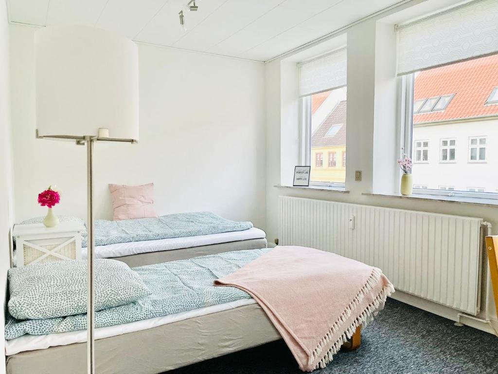um quarto com 2 camas e uma janela em Scandinavian Apartment Hotel - Tobaksgården - 2 room apartment em Horsens
