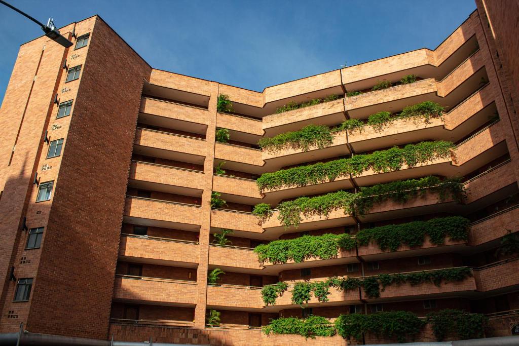 un edificio con plantas a su lado en Portal del Rodeo ApartaHotel, en Medellín