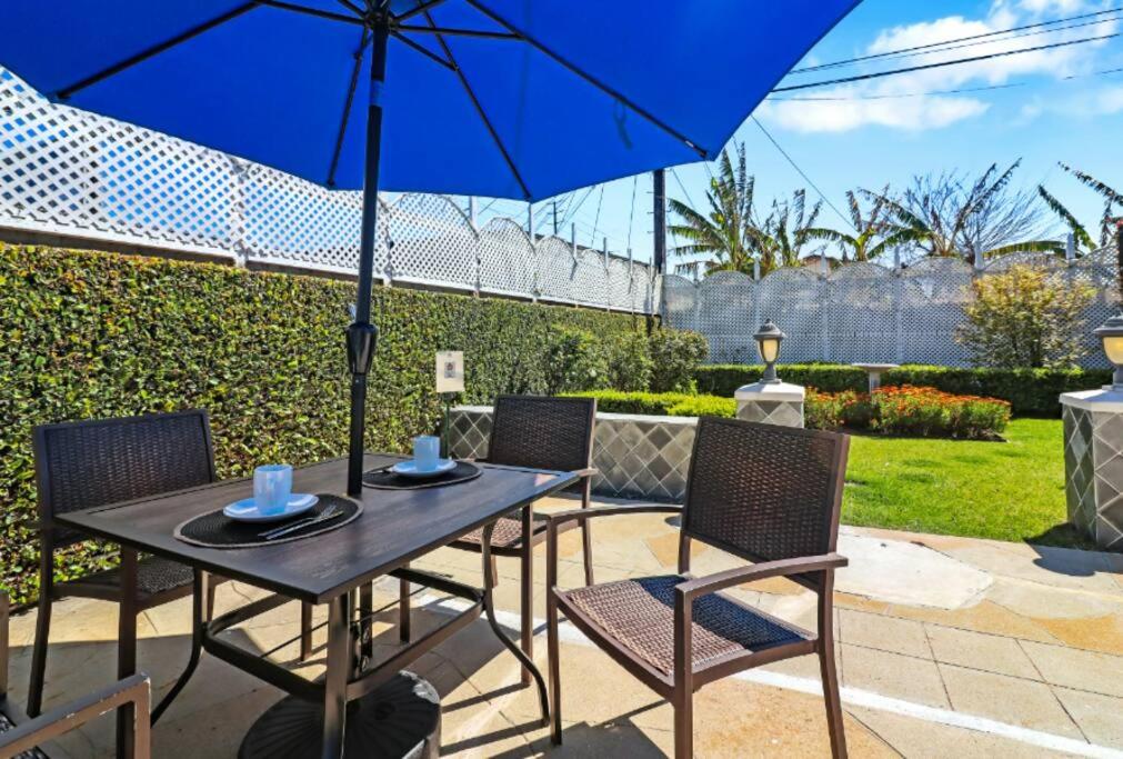 a table and chairs with an umbrella on a patio at Huge Studio - 7min LAX 405 SoFi in Hawthorne