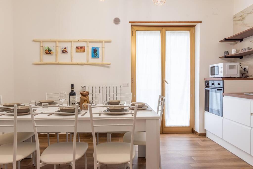 - une cuisine blanche avec une table et des chaises blanches dans l'établissement Da Zietta casa dal sapore tipico, à Castellana Grotte
