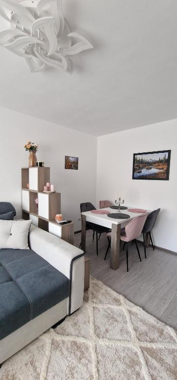 - une chambre avec un lit et une salle à manger dans l'établissement All In Jacuzzi Apartment, à Petroşani