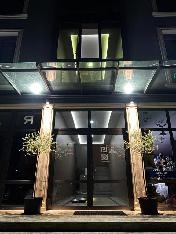 a store front with a glass door at night at Hotel Rita House in Pizunda