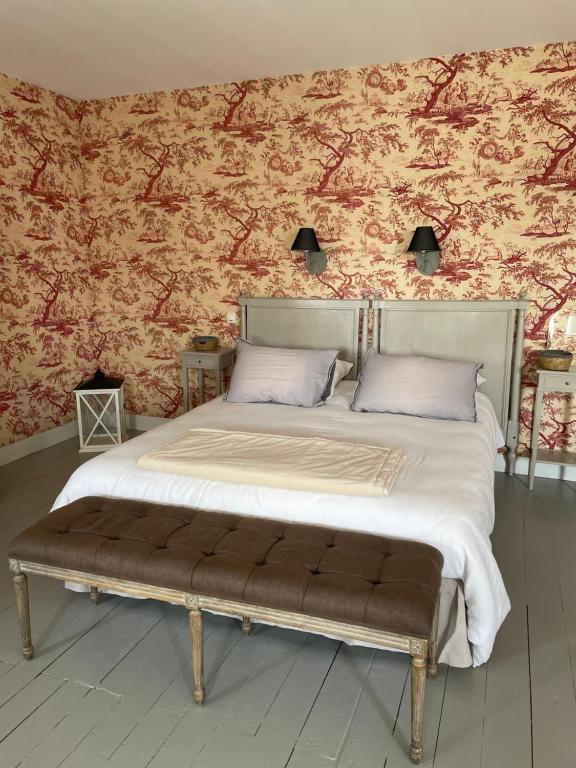 a bedroom with a bed with a bench in it at Belle Fontaine in Bourges