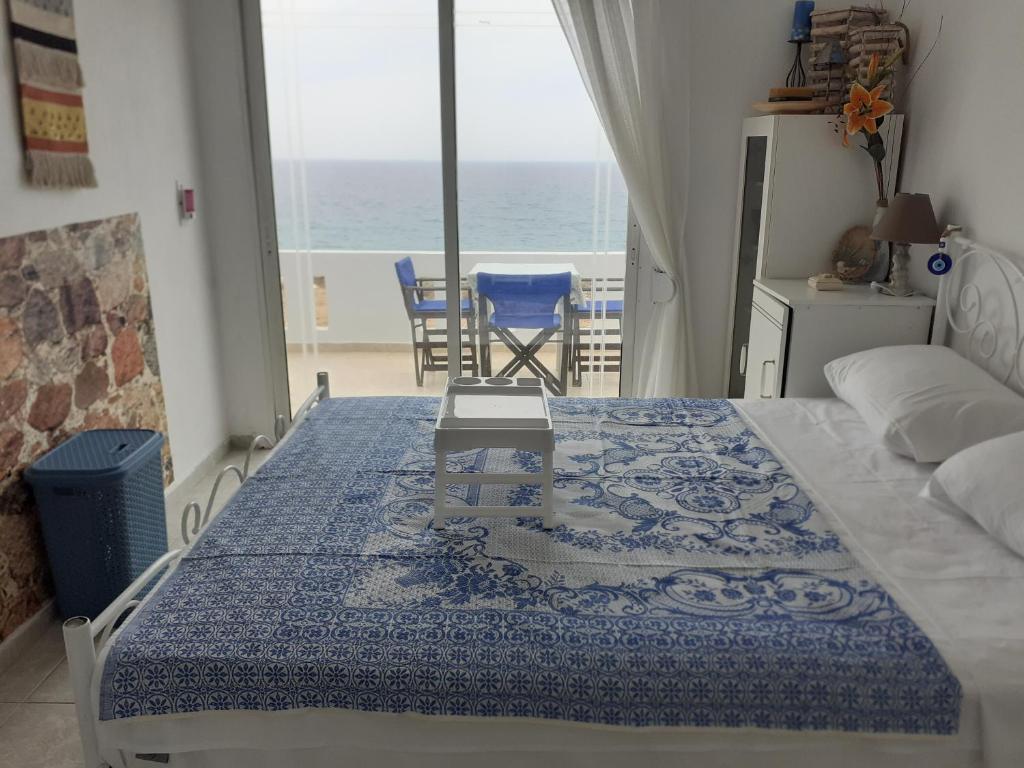 a bedroom with a bed and a view of the ocean at Seafront Aegean Νest in Karpathos Town