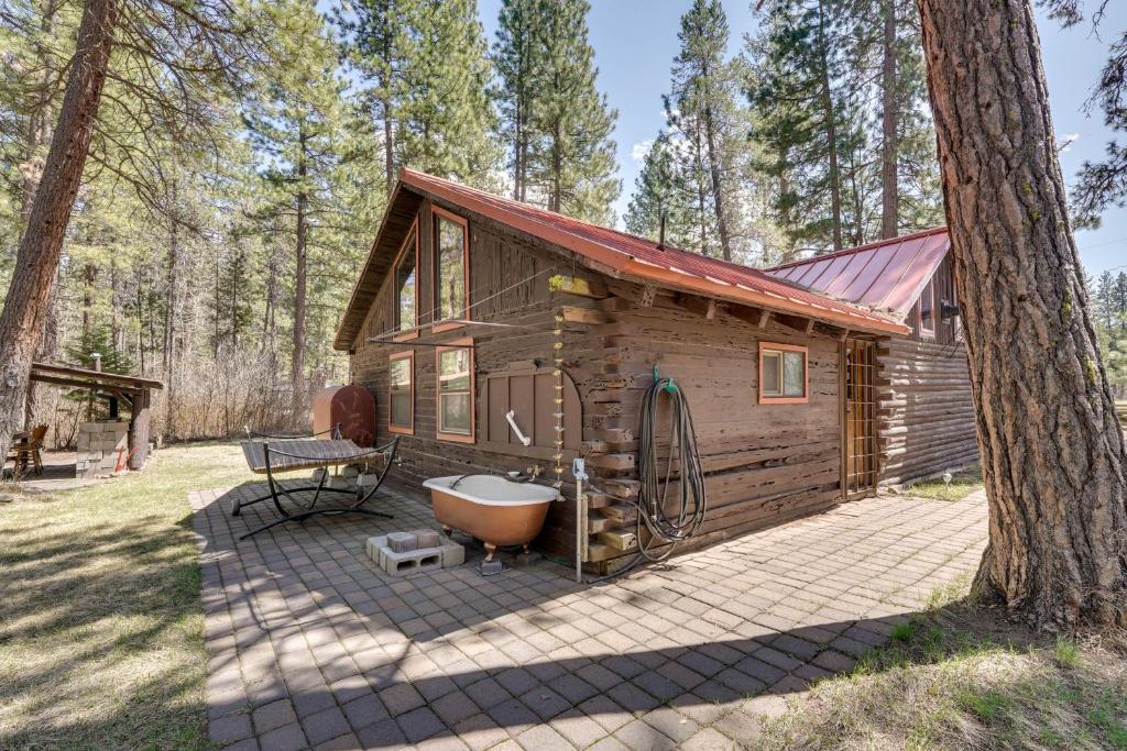 a cabin with a bath tub and a tree at Remote Escape Klamath Falls Cabin By Lake and Hikes in Klamath Falls