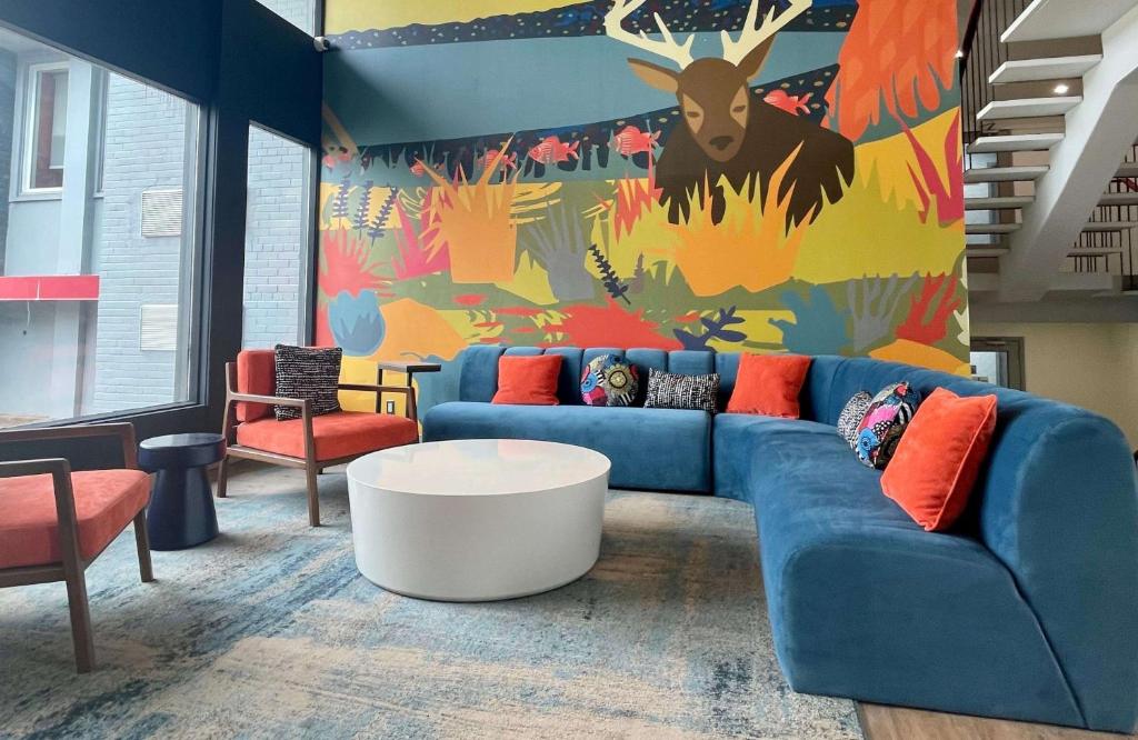 a living room with a blue couch and a colorful wall at Superior Shores Hotel, BW Signature Collection by Best Western in Thunder Bay