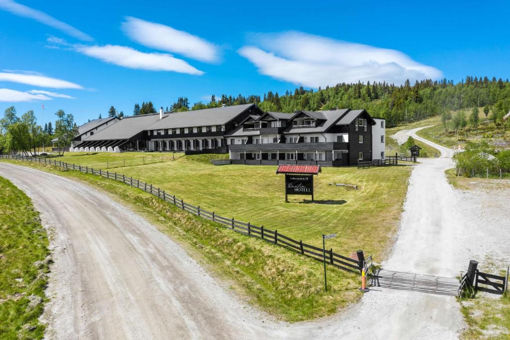 une maison sur un chemin de terre à côté d'un chemin de terre dans l'établissement Ranten Hotell Best Western Signature Collection, à Nesbyen