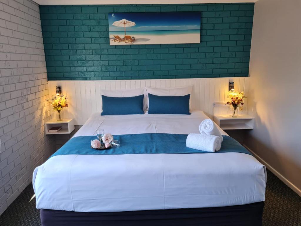 - une chambre avec un grand lit et deux lampes dans l'établissement Marco Polo Motor Inn Taree, à Taree