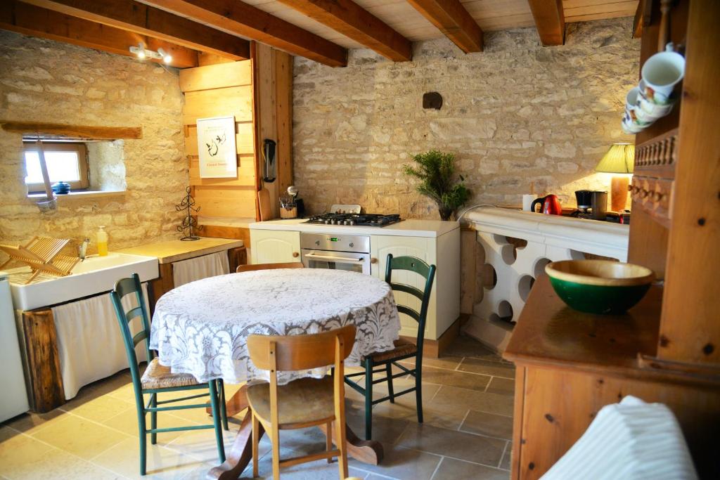 eine Küche mit einem Tisch und Stühlen im Zimmer in der Unterkunft Maison d'une chambre a Perrigny sur Armancon in Perrigny-sur-Armançon