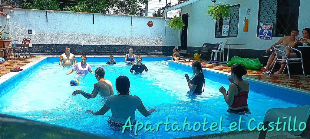 grupa ludzi siedzących w basenie w obiekcie Aparta Hotel el Castillo w mieście Melgar