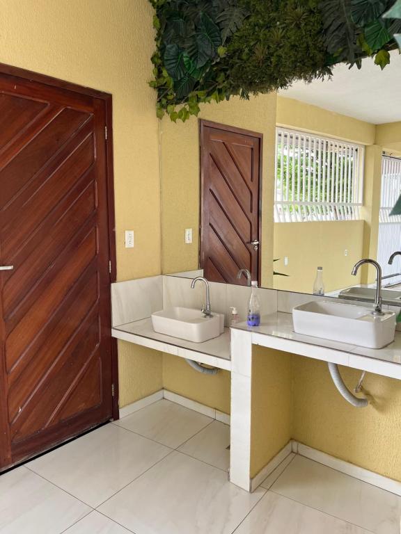 een badkamer met 2 wastafels en een houten deur bij São José Village in Sobral