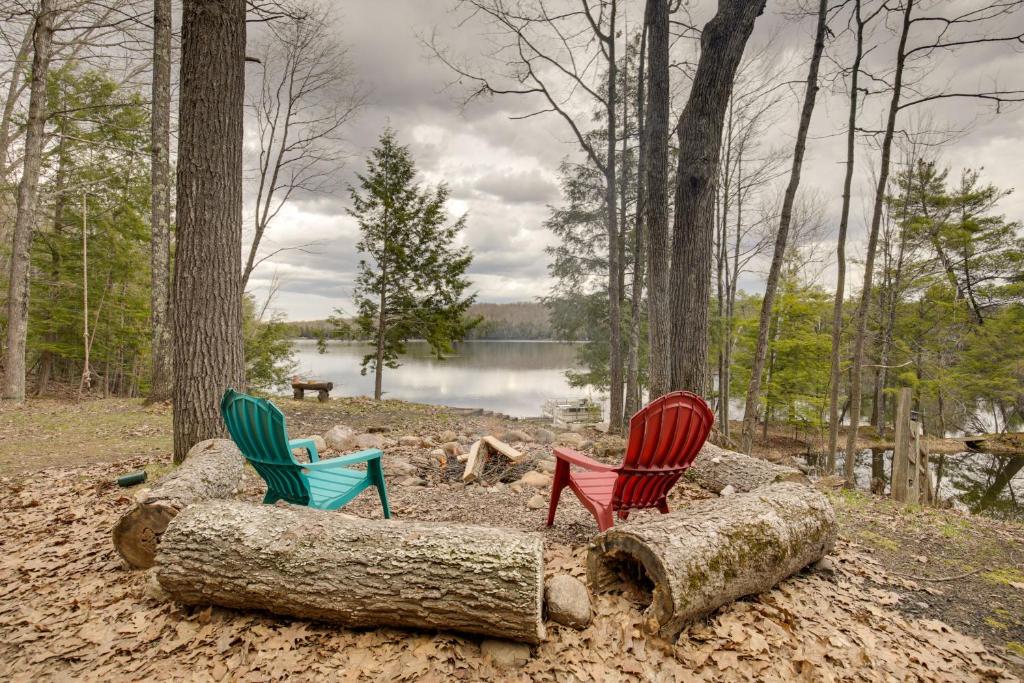 un gruppo di tre sedie seduti sopra un tronco di Lakefront Fence Home with Private Hot Tub! 