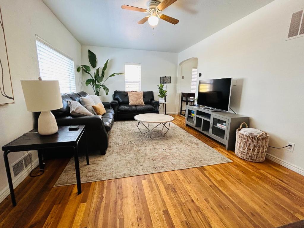 a living room with a black couch and a flat screen tv at Home Sweet Idahome, feels like home with all the decor you wish you could afford King bed in master, fully fenced dog friendly yard, a few blocks from BSU and downtown Boise, Your perfect stay! in Boise