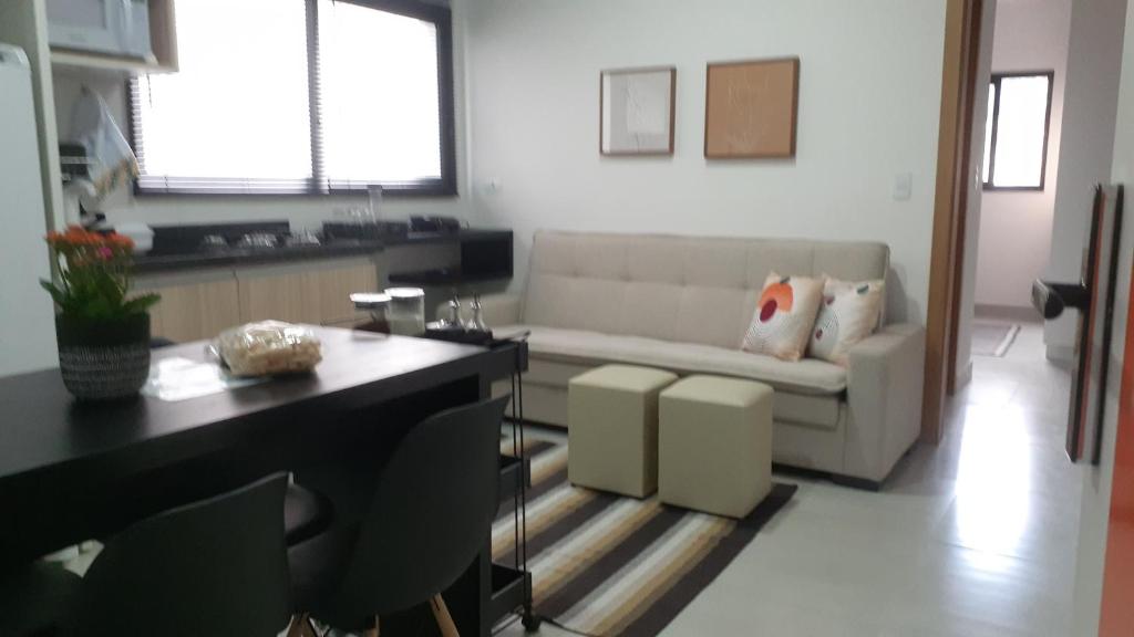 a living room with a couch and a table at Aconchego no centro de Poços! in Poços de Caldas