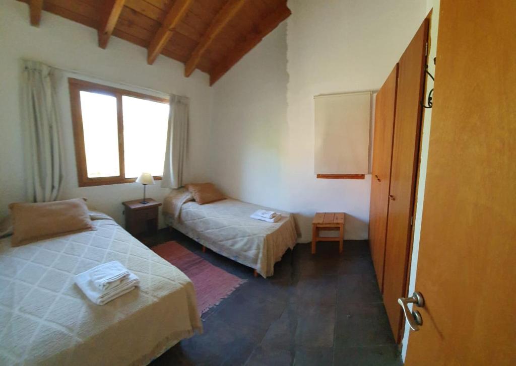 a hotel room with two beds and a window at Casa Catedral Bariloche in San Carlos de Bariloche